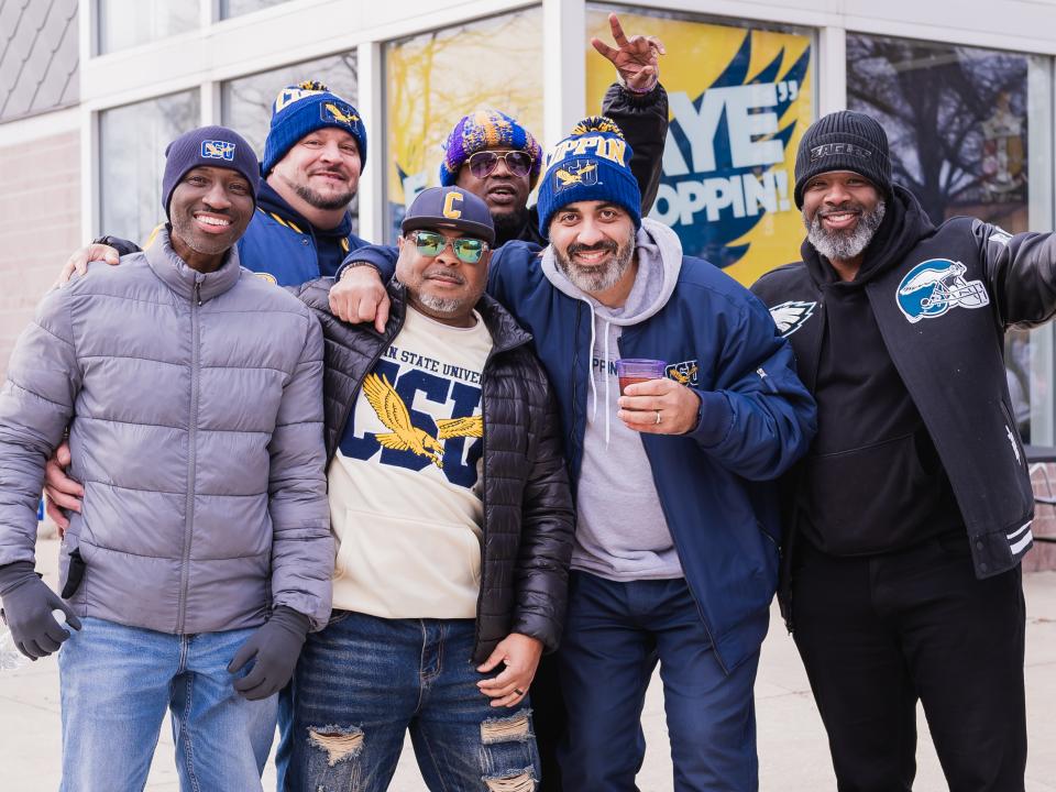 A group of Coppin male alums posing for a photo outside during homecoming 2025