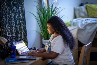 girl in dorm room at laptop