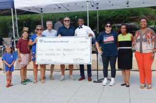 Group of people smiling and holding check