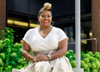Hope Mims of the class of 2003 seated outside on Coppin's campus