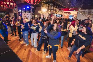 A Group Coppin alums dancing at 2025 Homecoming Happy Hour